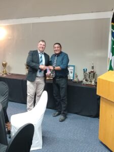 Defence (WP) Golf Club Awards Event 2025, showing B. February receiving a voucher during the prize presentation ceremony.