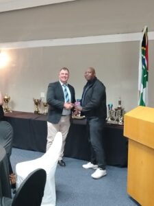 Defence (WP) Golf Club Awards Event 2025, showing M. Ncanana receiving a prize voucher during the awards ceremony.