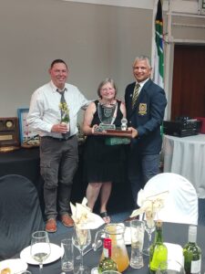 Defence (WP) Golf Club Awards Event 2025, showing A. Phillips and D. Phillips receiving the Chairman’s Award from the Chairperson during the awards ceremony.