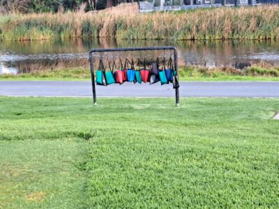Colourful sandbags available at the 10th tee at Milnerton Golf Club, placed near the tee box on the golf course.