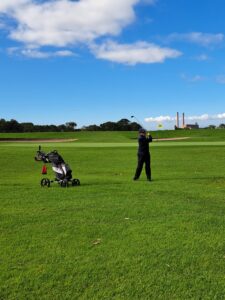 Golfer playing a fairway shot at Rondebosch Golf Club with the old power station chimneys in the distance, LIV 5, May 2026.
