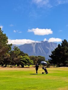 Golfer walking on the fairway at Royal Cape Golf Club with mountain views in the background, June 2026.